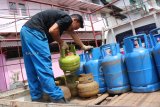 Seorang pria mengangkat tabung gas yang hendak didistribusikan untuk rumah makan di Jalan Gajahmada Pontianak, Kalbar, Rabu (12/12/2018). Manajer Fungsi Koordinasi, Komunikasi dan Kebijakan KPw Bank Indonesia Perwakilan Kalbar, Djoko Juniwarto menyatakan bahwa langkanya elpiji subsidi (gas melon) di wilayah Kalbar karena kondisi infrastruktur yang mengganggu distribusi barang serta perbedaan harga yang terlalu jauh dengan elpiji non subsidi. ANTARA FOTO/Jessica Helena Wuysang