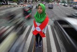 Mahasiswa Universitas Bhayangkara Surabaya berdiri dengan mengenakan pita merah saat melakukan aksi peringatan Hari AIDS Sedunia di Surabaya, Jawa Timur, Sabtu (1/12/2018). Aksi tersebut bertujuan untuk menggugah kesadaran masyarakat akan bahaya virus HIV/AIDS dan mengubah stigma negatif serta perlakuan diskriminatif bagi para penderitanya. Antara Jatim/Moch Asim/ZK