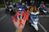 Mahasiswa Universitas Bhayangkara Surabaya menunjukkan pita merah yang akan dibagikan kepada pengguna jalan saat melakukan aksi peringatan Hari AIDS Sedunia di Surabaya, Jawa Timur, Sabtu (1/12/2018). Aksi tersebut bertujuan untuk menggugah kesadaran masyarakat akan bahaya virus HIV/AIDS dan mengubah stigma negatif serta perlakuan diskriminatif bagi para penderitanya. Antara Jatim/Moch Asim/ZK