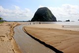 Panorama pantai Pulau Merah di Banyuwangi, Jawa Timur, Jumat (7/12/2018). Pulau merah yang tercipta dari perjalanan magma dibawah gunung api purba itu, telah ditetapkan sebagai situs Geopark Nasional karena singkapan batuan yang membentuk pulau sangat ideal dijadikan labolatorium geologi dunia untuk mempelajari proses alterasi dan mineralisasi emas tembaga. Antara Jatim/Budi Candra Setya/ZK.