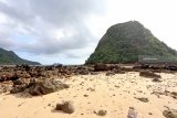 Panorama pantai Pulau Merah di Banyuwangi, Jawa Timur, Jumat (7/12/2018). Pulau merah yang tercipta dari perjalanan magma dibawah gunung api purba itu, telah ditetapkan sebagai situs Geopark Nasional karena singkapan batuan yang membentuk pulau sangat ideal dijadikan labolatorium geologi dunia untuk mempelajari proses alterasi dan mineralisasi emas tembaga. Antara Jatim/Budi Candra Setya/ZK.