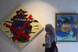 Pengunjung melihat lukisan karya seniman Ari Aitnat yang dipajang dalam pameran seni bertajuk 