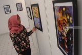 Pengunjung melihat lukisan batik karya seniman Nur Faazah yang dipajang dalam pameran seni bertajuk 