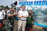 Menteri Koordinator Kemaritiman Luhut Binsar Pandjaitan (kedua kanan) mendengarkan penjelasan dari Komandan Satgas Citarum Harum Sektor 8 Kolonel Czi Aby Ismawan (kedua kiri) saat meninjau aliran sungai Citarum lama atau oxbow Cicukang di Kecamatan Margaasih, Kabupaten Bandung, Jawa Barat, Rabu (5/12/2018). Tahun 2019 Pemerintah pusat akan menggelontorkan anggaran hingga Rp 640 miliar untuk pembenahan Sungai Citarum. ANTARA JABAR/M Agung Rajasa/agr.

