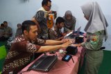 Petugas Dinas Kependudukan dan Pencatatan Sipil (Dispendukpencapil) melakukan proses perekaman Kartu Tanda Penduduk (KTP) elektronik di Sekolah Menengah Kejuruan (SMK) Yosonegoro, Kabupaten Magetan, Jawa Timur, Kamis (27/12/2018). Perekaman KTP elektronik di sekolah yang dilakukan Dispendukpencapil dan dipantau petugas Badan Pengawas Pemilu (Bawaslu) setempat tersebut sabagai tindak lanjut instruksi Kementerian Dalam Negeri guna memenuhi hak konstitusional para pemilih pemula. Antara Jatim/Siswowidodo/ZK.