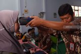 Petugas Dinas Kependudukan dan Pencatatan Sipil (Dispendukpencapil) melakukan proses perekaman Kartu Tanda Penduduk (KTP) elektronik di Sekolah Menengah Kejuruan (SMK) Yosonegoro, Kabupaten Magetan, Jawa Timur, Kamis (27/12/2018). Perekaman KTP elektronik di sekolah yang dilakukan Dispendukpencapil dan dipantau petugas Badan Pengawas Pemilu (Bawaslu) setempat tersebut sabagai tindak lanjut instruksi Kementerian Dalam Negeri guna memenuhi hak konstitusional para pemilih pemula. Antara Jatim/Siswowidodo/ZK.