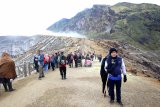 Pengunjung menikmati suasana di puncak Gunung Ijen, Banyuwangi, Jawa Timur, Sabtu (8/12/2018). Balai Konservasi Sumberdaya Alam (BKSDA) sedang menyusun aturan baru terkait pembatasan jumlah wisatawan yang mendaki Gunung Ijen pada tahun 2019, supaya tidak melebihi daya dukung kawasan agar tidak overload. Antara Jatim/Budi Candra Setya/ZK.