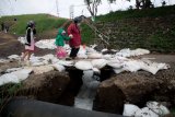 Warga melintas di atas tanggul yang retak dan Air mengalir deras dari tanggul Lumpur Lapindo Sidoarjo bocor di titik P71 Desa Ketapang, Tanggulangin, Sidoarjo, Jawa Timur, Jumat (28/12/2018).  Bocornya Tanggul penahan lumpur Lapindo akibat meluapnya lumpur di kolam penampungan yang merupakan imbas dari kian tingginya curah hujan dikawasan tersebut. Antara Jatim/Umarul Faruq/ZK.