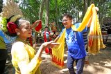 Wisatawan menari bersama penari di Desa Wisata Adat Osing Kemiren, Banyuwangi, Jawa Timur, Sabtu (8/12/2018). Penyambutan tamu dengan kesenian barong dan tari-tarian tersebut, selain menjadi seni pertunjukan bagi wisatawan juga dipercaya agar hawa roh jahat tidak ada yang masuk ke Desa Adat Kemiren. Antara Jatim/Budi Candra Setya/ZK.