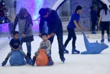 Sejumlah pengunjung berseluncur di atas hamparan es di arena 
