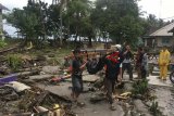 Petugas Basarnas dibantu warga mengevakuasi korban meninggal akibat tsunami di pesisir Cinangka, Serang, Banten, Minggu (23/12/2018). ANTARA JABAR/Basarnas/agr.
