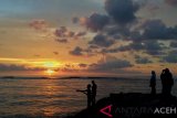 Warga menikmati matahari terbenam (sunset) akhir tahun 2018 di Pantai Lampuuk, Kecamatan Lhoknga, Kabupaten Aceh Besar, Aceh, Senin (31/12/2018).  Warga memanfaatkan libur akhir tahun dikawasan pantai untuk melihat matahari terbenam atau sunset serta menunggu pergantian tahun Masehi. (Antara Aceh/Zahlul Akbar)