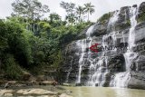 Pengunjung berfoto di kawasan wisata alam Curug Luhur Cigangsa, Surade, Kabupaten Sukabumi, Jawa Barat, Selasa (12/12/2018). Curug Luhur Cigangsa yang memiliki tinggi 50 meter serta menawarkan pemandangan alam dan suasana air terjun yang masih alami tersebut menjadi salah satu alternatif wisata liburan favorit bersama keluarga. ANTARA JABAR/Nurul Ramadhan/agr. 