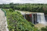 Pengunjung berfoto di kawasan wisata alam Geopark Ciletuh Curug Awang, Ciemas, Kabupaten Sukabumi, Jawa Barat, Minggu (09/12/2018). Curug Awang yang memiliki tinggi 40 meter dan lebar 60 meter serta menawarkan suasana pemandangan air terjun yang masih alami tersebut menjadi alternatif wisata liburan di akhir pekan bersama keluarga. ANTARA JABAR/Nurul Ramadhan/agr. 