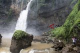 Pengunjung berfoto di kawasan wisata alam Geopark Curug Cimarinjung, Ciemas, Kabupaten Sukabumi, Jawa Barat, Minggu (16/12/2018). Curug Cimarinjung yang menawarkan pemandangan alam serta suasana deburan air terjun yang masih alami tersebut menjadi salah satu alternatif destinasi wisata liburan favorit bersama keluarga di akhir pekan. ANTARA JABAR/Nurul Ramadhan/agr. 