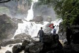 Pengunjung menikmati air terjun di kawasan wisata alam Geopark Curug Cimarinjung, Ciemas, Kabupaten Sukabumi, Jawa Barat, Minggu (16/12/2018). Curug Cimarinjung yang menawarkan pemandangan alam serta suasana deburan air terjun yang masih alami tersebut menjadi salah satu alternatif destinasi wisata liburan favorit bersama keluarga di akhir pekan. ANTARA JABAR/Nurul Ramadhan/agr. 