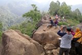 Wisatawan menikmati pemandangan alam berlatar belakang air terjun Sedudo di Bukit Watu Lawang, Nganjuk, Jawa Timur, Minggu (2/12/2018). Wisata di lereng gunung Wilis yang dibuka untuk umum pada tahun 2017 tersebut menjadi populer dan banyak dicari pengunjung dari sejumlah daerah karena publikasi media sosial. Antara Jatim/Prasetia Fauzani/ZK