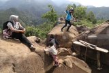 Wisatawan menikmati pemandangan alam berlatar belakang air terjun Sedudo di Bukit Watu Lawang, Nganjuk, Jawa Timur, Minggu (2/12/2018). Wisata di lereng gunung Wilis yang dibuka untuk umum pada tahun 2017 tersebut menjadi populer dan banyak dicari pengunjung dari sejumlah daerah karena publikasi media sosial. Antara Jatim/Prasetia Fauzani/ZK