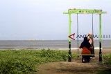 Pengunjung berwisata dikawasan pantai Karangsong, Indramayu, Jawa barat, Rabu (26/12/2018). Sejak beberapa hari terakhir, sejumlah objek wisata di pesisir Indramayu sepi pengunjung karena beredar isu gelombang tinggi dan laut pasang. ANTARA JABAR/Dedhez Anggara.