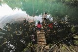 Pengunjung menikmati suasana telaga biru Cirereum, Kuningan, Jawa Barat, Jumat (7/12/2018). Telaga Cirerem yang terletak di lembah gunung Ciremai merupakan salah satu tujuan wisata di Kabupaten Kuningan yang kian banyak menarik minat wisata. ANTARA JABAR/Dedhez Anggara/agr.