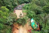 Alat berat membersihkan material longsor yang menghantam tiga unit kendaraan, di Jalur Lintas Padang - Jambi, Panorama II Sitinjau Lauik, Padang, Sumatera Barat, Jumat (14/12/2018). Longsor terjadi pada Kamis (13/12) malam tersebut mengakibatkan satu unit bis, truk, dan minibus terseret ke pinggir jurang dan membuat lima orang luka-luka serta satu orang meninggal dunia. ANTARA FOTO/Iggoy el Fitra