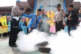 Seorang mahasiswa menahan petugas kepolisian yang hendak memadamkan api dari ban yang dibakar saat unjukrasa Persatuan Mahasiswa Islam Indonesia (PMII) Kalbar di Kantor PT Pertamina, Pontianak, Jumat (14/12/2018). Mereka menuntut Pemerintah Provinsi Kalbar dan PT Pertamina (Persero) untuk mengatasi kelangkaan gas elpiji tiga kilogram, serta menindaklanjuti temuan praktik nakal rumah makan dan restoran di Kalbar yang masih menggunakan gas bersubsidi. ANTARA FOTO/Jessica Helena Wuysang