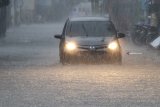 Pengguna jalan berusaha melintasi genangan banjir di jalan Gajayana, Malang, Jawa Timur, Senin (10/12/2018). Hujan deras yang melanda kawasan tersebut mengakibatkan banjir di sejumlah titik.  Antara Jatim/HO/H Prabowo/ZK.