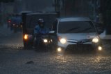 Pengguna jalan berusaha melintasi genangan banjir di jalan Gajayana, Malang, Jawa Timur, Senin (10/12/2018). Hujan deras yang melanda kawasan tersebut mengakibatkan banjir di sejumlah titik.  Antara Jatim/HO/H Prabowo/ZK.