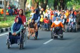 Sejumlah penyandang disabilitas fisik mengikuti jalan sehat bersama insan disabilitas di Surabaya, Jawa Timur, Minggu (2/12/2018). Kegiatan yang diikuti sekitar 2.700 peserta dari 119 kelompok dan lembaga se-Jawa Timur tersebut untuk menyemarakkan Hari Disabilitas Internasional 2018. Antara Jatim/M Risyal Hidayat/ZK