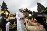 Seorang pemangku memberikan air suci pada umat dalam perayaan Galungan di Pura Jagat Karana Surabaya, Jawa Timur, Rabu (26/12/2018). Umat Hindu di Surabaya merayakan hari raya Galungan setiap enam bulan sekali sebagai hari tanda hari kemenangan (Dharma) atas kejahatan (Adharma). Antara Jatim/M Risyal Hidayat/ZK.