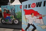 Pengunjung (kiri) berpose di salah satu spot foto saat acara Jokowi Millennials Festival di Surabaya, Jawa Timur, Sabtu (8/12/2018). Kegiatan yang dimeriahkan dengan bazar UMKM, 