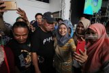 Menteri PUPR Basuki Hadimuljono (tengah) melayani permintaan swafoto pengunjung saat acara Jokowi Millennials Festival di Surabaya, Jawa Timur, Sabtu (8/12/2018). Kegiatan yang dimeriahkan dengan bazar UMKM, 