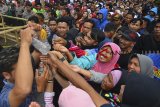 Sejumlah warga berebut air bekas pencucian benda pusaka peninggalan Prabu Sanghyang Borosngora dari Kerajaan Panjalu seusai upacara Adat Nyangku di Alun-alun Panjalu, Kabupaten Ciamis, Jawa Barat, Senin (3/12/2018). Warga percaya bahwa air cikahuripan yang diambil dari 20 sumber mata air yang ada di wilayah Panjalu tersebut dapat mendatangakan keberkahan dan menyuburkan tanaman. ANTARA JABAR/Adeng Bustomi/agr.