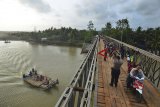 Warga menyebrang di Jembatan Bailey Pansel yang sudah bisa dilalui pasca putus akibat diterjang banjir bandang di Desa Ciheras, Cipatujah, Kabupaten Tasikmalaya, Jawa Barat, Kamis (13/12/2018). Jembatan tersebut baru diresmikan untuk bisa dilalui kembali para pengguna jalan dan kendaraan oleh Direktorat Jenderal Bina Marga Kementerian PUPR. ANTARA JABAR/Adeng Bustomi/agr.