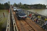 Warga menyebrang di Jembatan Bailey Pansel yang sudah bisa dilalui pasca putus akibat diterjang banjir bandang di Desa Ciheras, Cipatujah, Kabupaten Tasikmalaya, Jawa Barat, Kamis (13/12/2018). Jembatan tersebut baru diresmikan untuk bisa dilalui kembali para pengguna jalan dan kendaraan oleh Direktorat Jenderal Bina Marga Kementerian PUPR. ANTARA JABAR/Adeng Bustomi/agr.