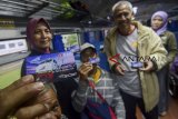 Penumpang menunjukan kartu tapcash BNI saat acara peluncuran Kereta Api Galunggung di Stasiun Kiaracondong, Bandung, Jawa Barat, Rabu (26/12/2018). PT. KAI meluncurkan Kereta Api Galunggung  dengan rute Kiaracondong-Tasikmalaya dengan promo tiket gratis selama satu bulan serta pembelian tiket dapat menggunakan tap cash BNI. ANTARA JABAR/Raisan Al Farisi/agr. 