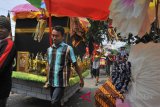 Sejumlah warga menggotong aneka barang sedekah yang dihias warna-warni saat menggelar acara tradisi Panjang Mulud di Kampung Tanggul, Serang, Banten, Senin (3/12/2018). Tradisi tersebut dilangsungkan untuk menyambut bulan kelahiran Nabi Muhammad atau Bulan Mulud dalam kalender Jawa dengan mengumpulkan sedekah untuk kemudian dibagikan kepada fakir miskin. ANTARA FOTO/Weli Ayu Rejeki/af/