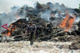 Pemulung membakar sampah plastik dan barang bekas lainnya di tempat pengolahan limbah kertas dan plastik di Desa Bangun, Pungging, Mojokerto, Selasa (11/12/2018). Guru Besar Pengelolaan Udara dan Limbah Institut Teknologi Bandung (ITB), Enri Damanhuri, mengungkapkan tiap tahun sekitar 44 persen sampah plastik alias 2,13 juta ton cemari lingkungan. ANTARA FOTO/Umarul Faruq/ama.