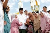 Warga berfoto dengan Presiden Joko Widodo setelah penyerahan sertifikat tanah wakaf kepada pengurus masjid, mushola dan pasantren seusai melaksanakan ibadah Jumat di Banda Aceh, Aceh, Jumat (14/12/2018). Pemerintah telah membagikan lima juta sertifikat tanah termasuk tanah wakaf pada 2016 dan menargetkan tujuh juta sertifikat pada 2018 serta sembilan juta sertifikat tanah pada 2019 mendatang. (ANTARA FOTO/Irwansyah Putra/pd.)