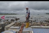 Warga berdiri di atas bekas rumahnya yang hancur diterjang gelombang tsunami Selat Sunda di Kecamatan Sumur, Pandeglang, Banten, Selasa (25/12/2018). ANTARA FOTO/Muhammad Adimaja/ama.