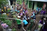 Warga bersama relawan dan TNI bergotong royong membersihkan rumah warga korban banjir bandang di Desa Jedong, Ngoro, Mojokerto, Jawa Timur, Sabtu (19/1/2019).  Banjir bandang berupa material batu, pepohonan, dan lumpur dari lereng Gunung Penanggungan yang terjadi pada Jumat (18/1) petang tersebut memutus jalan desa dan merusak sejumlah rumah. Antara Jatim/Umarul Faruq/ZK.