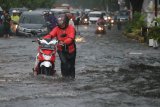 Warga mendorong motornya yang mogok di Jalan Ngagel Jaya Selatan, Surabaya, Jawa Timur, Sabtu (19/1/2019). Hujan deras selama sekitar empat jam yang mengguyur kota Surabaya menyebabkan sejumlah kawasan di kota Surabaya tergenang air. Antara Jatim/Didik Suhartono/ZK.