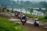 Sejumlah pengendara sepeda motor melewati tanggul penahan lumpur Lapindo, Porong, Sidoarjo, Jawa Timur, Sabtu (19/1/2019). Pengendara sepeda motor tersebut tidak bisa melewati jalan raya Porong yang terendam air setinggi 70 cm akibat curah hujan yang tinggi sejak Jumat (18/1) malam. Antara Jatim/Umarul Faruq/ZK.