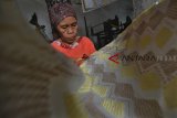 Perajin menyelesaikan pembuatan batik tulis dikain sutra dirumah produksinya Desa Cipondok, Kabupaten Tasikmalaya, Jawa Barat, Kamis (3/1/2019). Perajin kain sutra mengembangkan inovasi baru dengan membuat kain sutra dipadukan dengan motif batik tulis dengan harga Rp 6.500.000 per potong yang dipasarkan ke berbagai daerah di Jabar dan Jabodetabek. ANTARA JABAR/Adeng Bustomi/agr. 