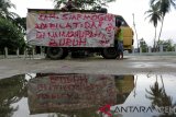 Buruh bongkar muat terminal mobil barang Santan memajang spanduk ancaman mogok kerja di Aceh Besar, Aceh, Rabu (9/1/2019). Sekitar 500 orang buruh bongkar muat barang diterminal barang tersebut meminta para pengusaha dan perusahaan angkutan untuk menaikan upah dari 10 persen menjadi 20 persen. (Antara Aceh/Irwansyah Putra)