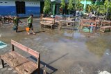 Siswa membawa air untuk membersihkan ruang kelas saat hari pertama masuk sekolah di SDN Kraton 3, Kencong, Jember, Jawa Timur, Rabu (2/1/2019). Siswa-siswa membersihkan ruang kelas pascabanjir akibat tanggul jebol dan sekolah itu dijadikan lokasi pengungsian dan posko penanganan bencana. Antara Jatim/Seno/ZK.