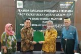 Regional Head V Bank Syariah Mandiri (BSM) Gunawan Arif Hartoyo (kedua kiri) dan Ketua Umum Yayasan Rumah Sakit Islam Surabaya (Yarsis) Mohammad Nuh (kedua kanan) menunjukkan nota kerja sama antara BSM dan Yarsis usai ditandangani di Surabaya, Jawa Timur, Jumat (18/1/2019). Kerja sama antara BSM dan Yarsis tersebut berupa pembiayaan tagihan Islamic-Banking Supplier Financing (iB-SF) fasilitas kesehatan rekanan BPJS atau talangan BPJS Kesehatan untuk mempercepat arus kas dan perputaran modal serta mendorong peningkatan kualitas pelayanan kesehatan kepada masyarakat. Antara Jatim/Moch Asim/ZK.