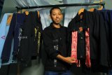 Pelaku ekonomi kreatif (Ekraf) Pontianak Harivo Santoso memperlihatkan jaket denim tenun songket di Studio Oy di Pontianak, Kalimantan Barat, Jumat (18/1/2019). Jaket denim menggunakan kain tenun dan songket khas Kalbar yang dirancang Harivo dan telah didaftarkan ke Kemenkumham untuk mendapatkan Hak Atas Kekayaan Intelektual (HaKI) tersebut dijual seharga Rp350 ribu hingga Rp500 ribu per helai. ANTARA FOTO/Jessica Helena Wuysang