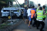 Petugas dan warga berusaha mengevakuasi mobil Mitsubisi L300 bernopol P 1264 DE dalam kondisi ringsek usai terlibat kecelakaan dengan kereta api di lintasan rel KA di Dusun Rohkepuh, Beji, Pasuruan, Jawa Timur, Rabu (9/1/2019). Kecelakaan di perlintasan tanpa palang tersebut mengakibatkan lima orang meninggal dunia dan satu mengalami luka kritis. Antara Jatim/Ridwan/ZK