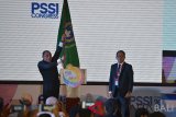 Ketua Umum PSSI Edy Rahmayadi (kiri) mengangkat bendera organisasi sepak bola Indonesia itu sebelum menyerahkannya kepada Wakil Ketua Umum PSSI Djoko Driyono setelah menyampaikan pengunduran dirinya dalam pembukaan Kongres PSSI 2019 di Nusa Dua, Bali, Minggu (20/1/2019). Djoko Driyono resmi menjabat Ketua Umum PSSI. ANTARA FOTO/Nyoman Budhiana.